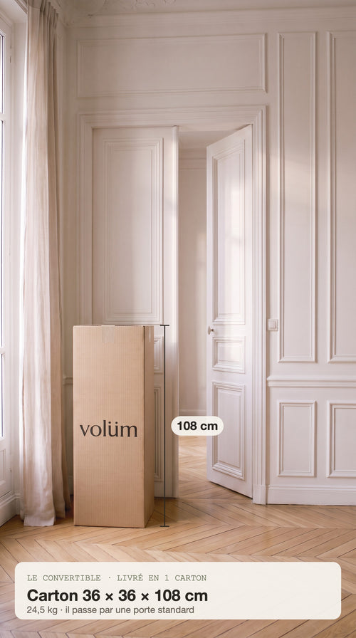 Le carton du Convertible, 36 × 36 × 108 cm, posé à côté de la porte du salon