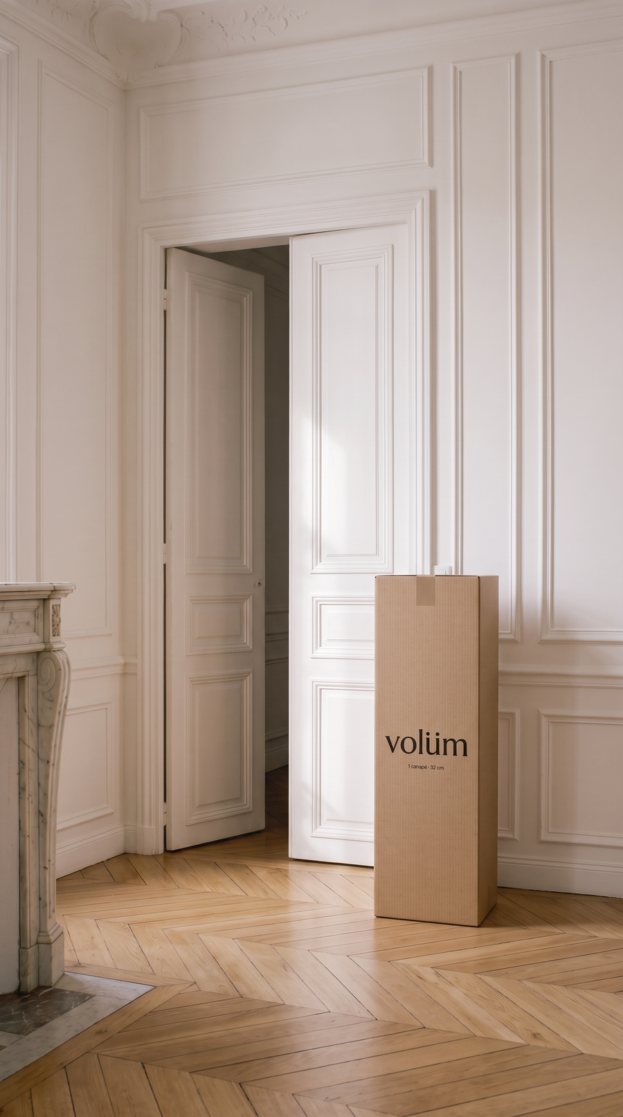 Le carton Volüm posé à côté de la porte du salon